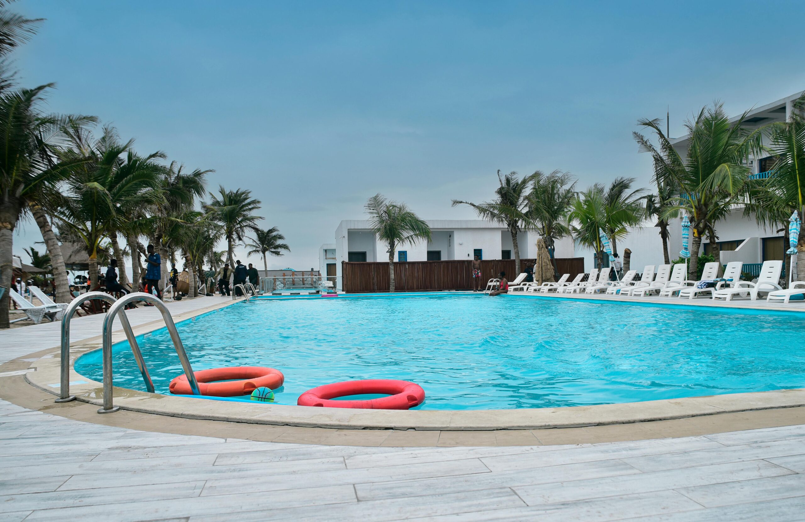 Serene poolside view at a luxury resort with palm trees and clear blue skies.